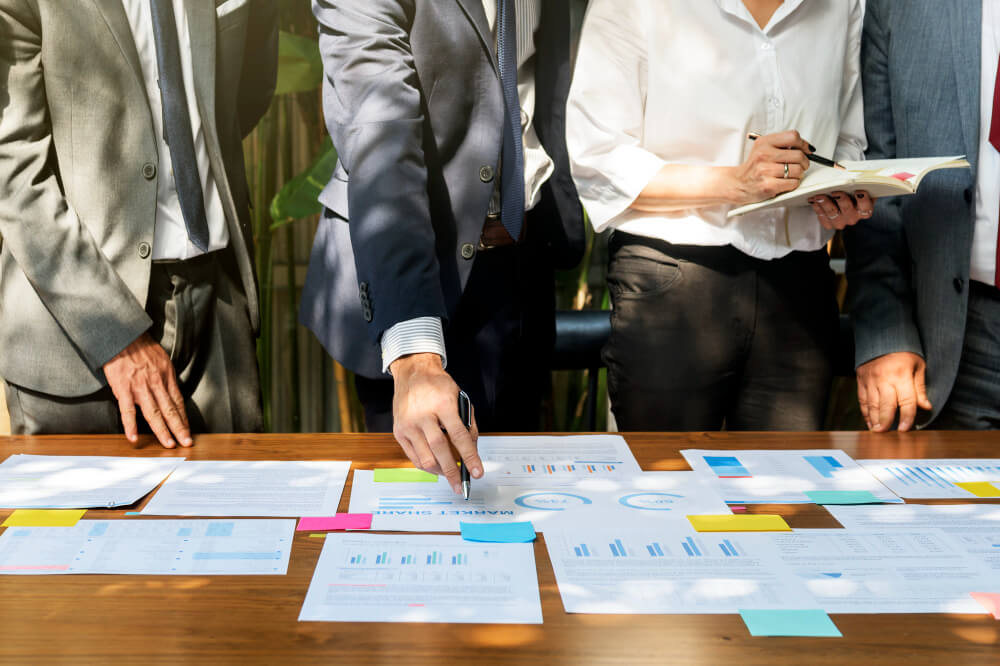 Business professionals in Manitoba reviewing financial charts and documents during a small business succession planning meeting, illustrating legal and operational strategies for succession planning in Manitoba.
