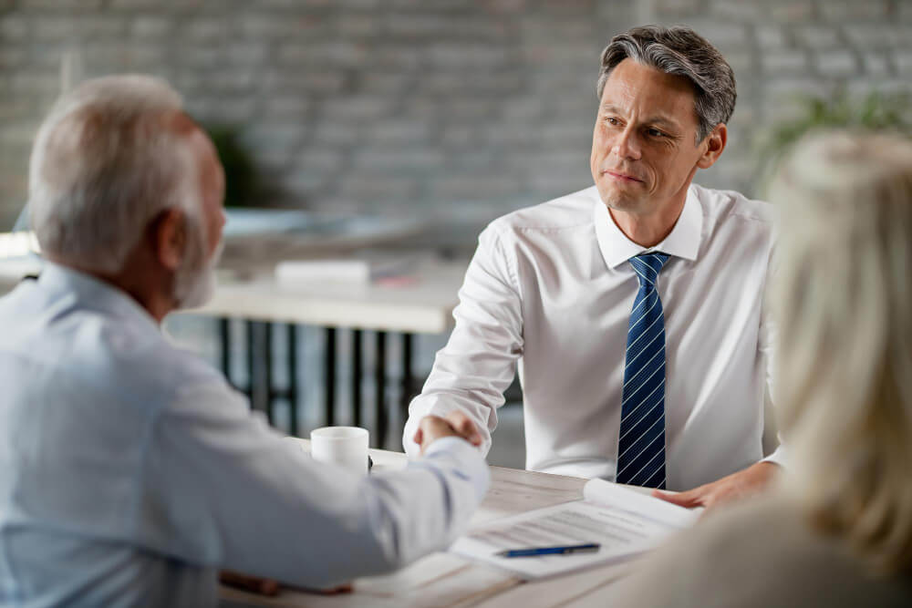 Client shaking hands with a lawyer during a consultation, representing choosing the right executor and estate planning decisions with guidance from TLR Law in Manitoba.
