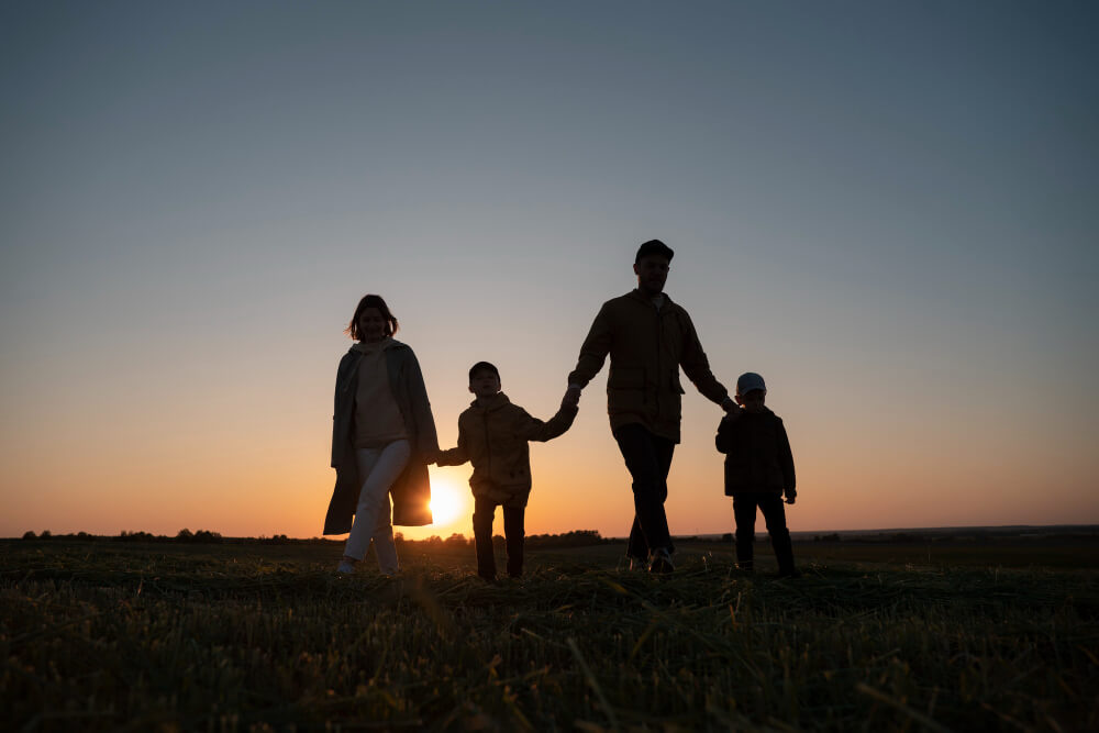 Parents walking with their children at sunset, representing the changing legal role of parents when a child turns 18 and young adult planning with TLR Law in Manitoba.