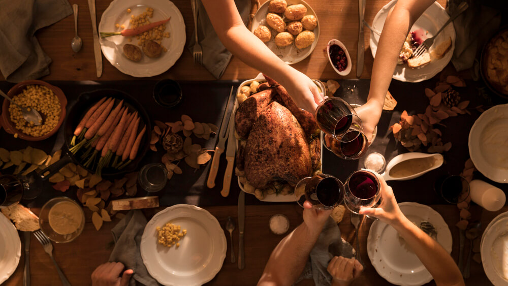 Family sharing Thanksgiving dinner together, representing conversations about wills, executors, and estate planning with TLR Law in Winnipeg, Manitoba.