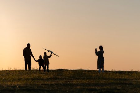 Silhouette of a family enjoying time together at sunset, symbolizing love, connection, and shared values—key considerations when choosing guardians for children, as discussed by TLR Law in Winnipeg.