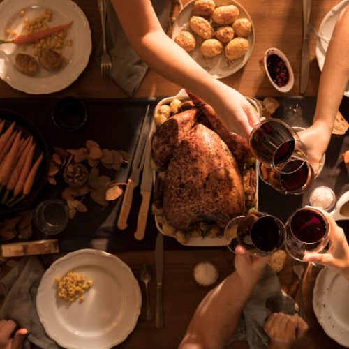 Family sharing Thanksgiving dinner together, representing conversations about wills, executors, and estate planning with TLR Law in Winnipeg, Manitoba.