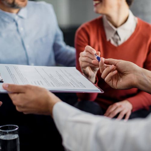 Couple reviewing legal documents with a professional, representing executor responsibilities and estate administration after a death in Manitoba.