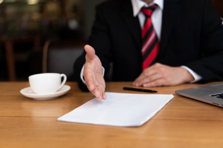 Lawyer reaching out to review and sign a power of attorney document, highlighting the importance of an enduring POA for financial and property decisions with TLR Law in Manitoba.