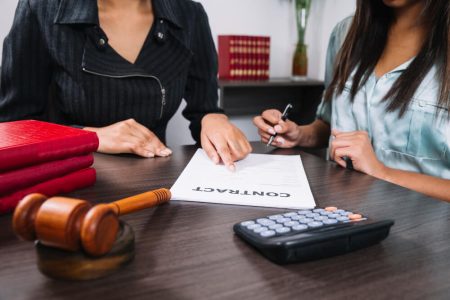 Lawyer guiding a client through signing a power of attorney contract, symbolizing the importance of choosing a trustworthy person to handle financial and legal affairs in Manitoba.