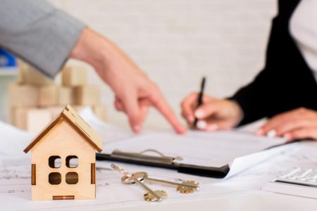 House model, keys, and legal documents during an estate consultation, representing the process of inheriting and transferring a home with guidance from TLR Law in Manitoba.
