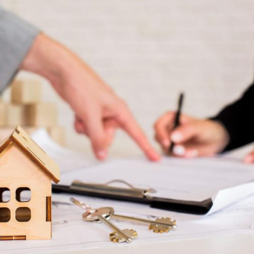 House model, keys, and legal documents during an estate consultation, representing the process of inheriting and transferring a home with guidance from TLR Law in Manitoba.