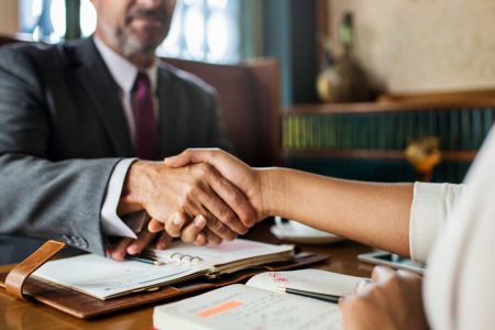 A professional handshake between a TLR Law Firm representative and a client during a meeting in Manitoba, symbolizing guidance and trust in the executor role process.